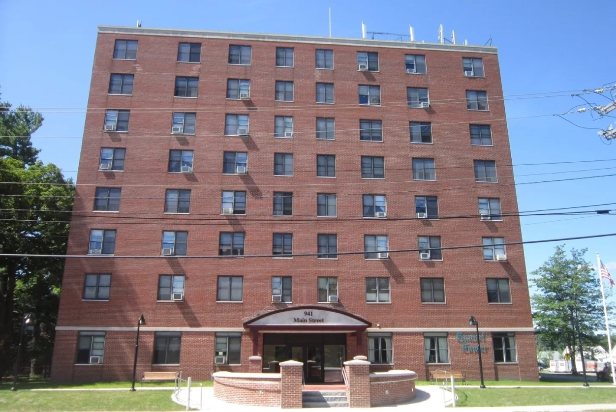 A large brick building with many windows and a small entrance.