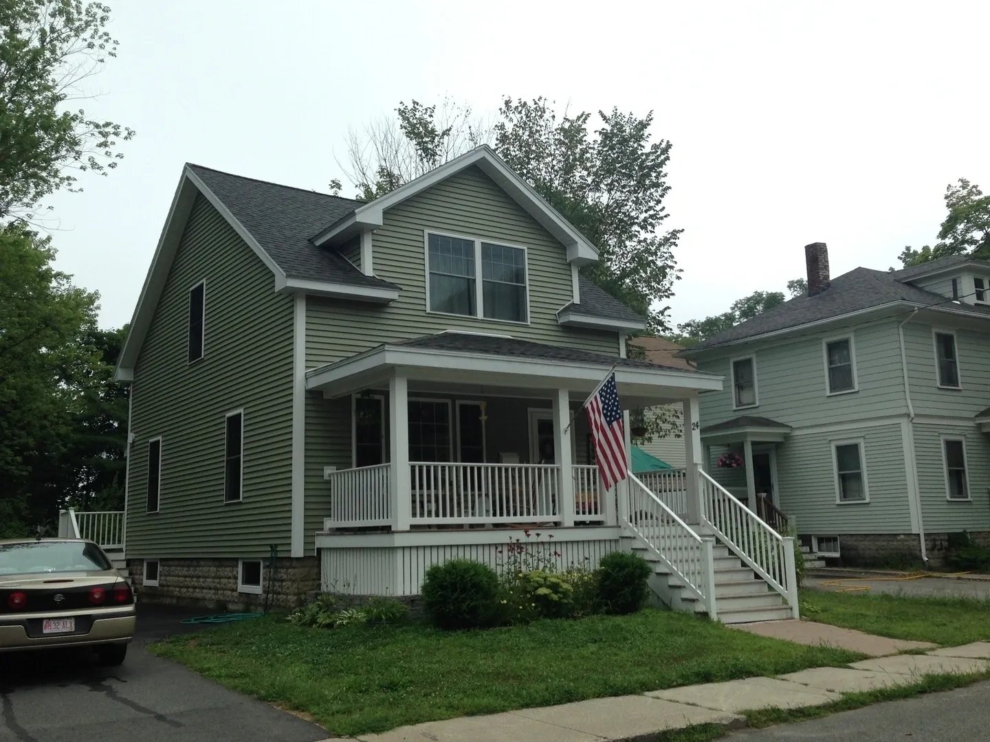 A house with an american flag on the front porch.