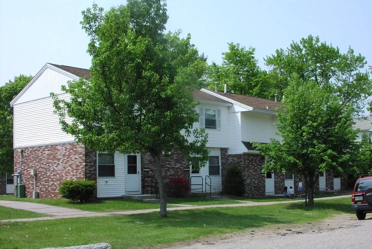 A row of houses with trees in the background.